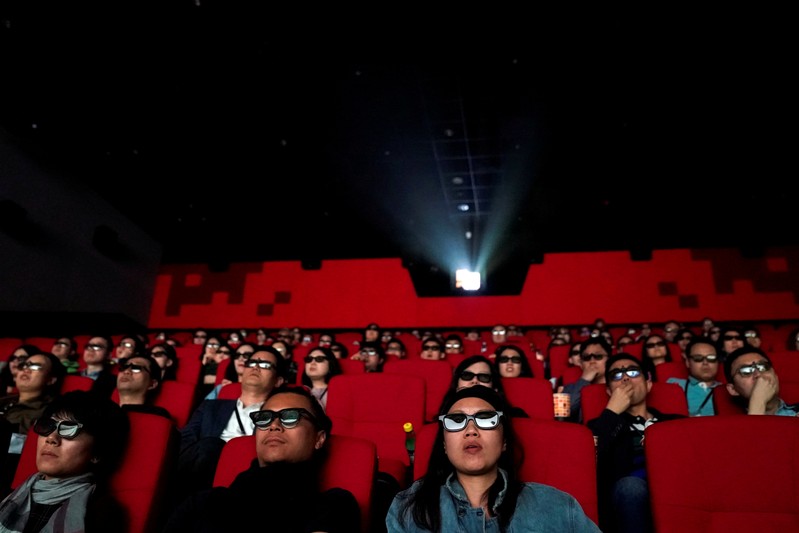 FILE PHOTO: People watch a movie at a cinema in Wanda Group's Oriental Movie Metropolis ahead of its opening, in Qingdao