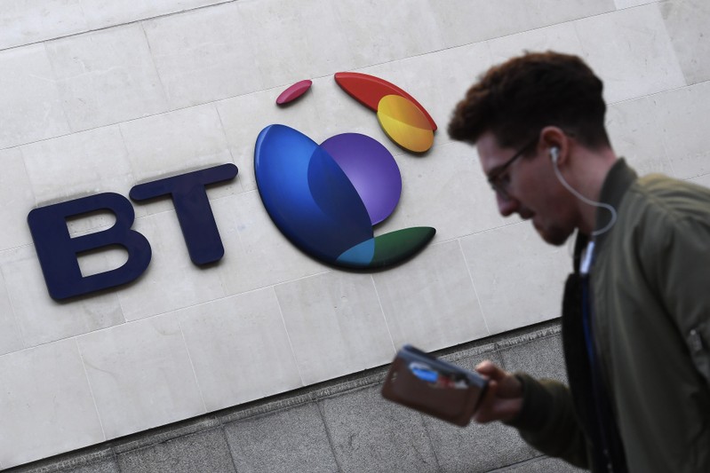 FILE PHOTO: A man walks past a BT logo outside of offices in the City of London