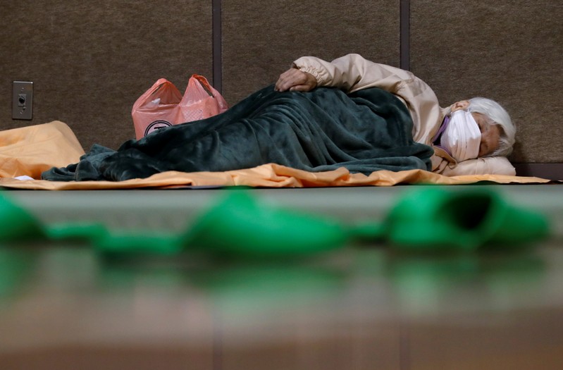 A woman sleeps in the evacuation centre for affected by the flood after Typhoon Hagibis in Nagano