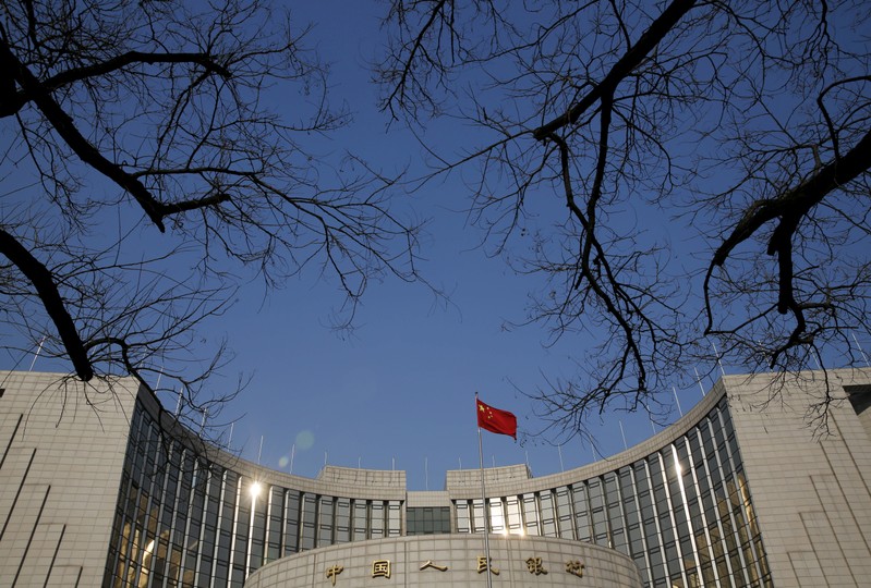 FILE PHOTO: A Chinese national flag flies at the headquarters of the People's Bank of China, the country's central bank, in Beijing