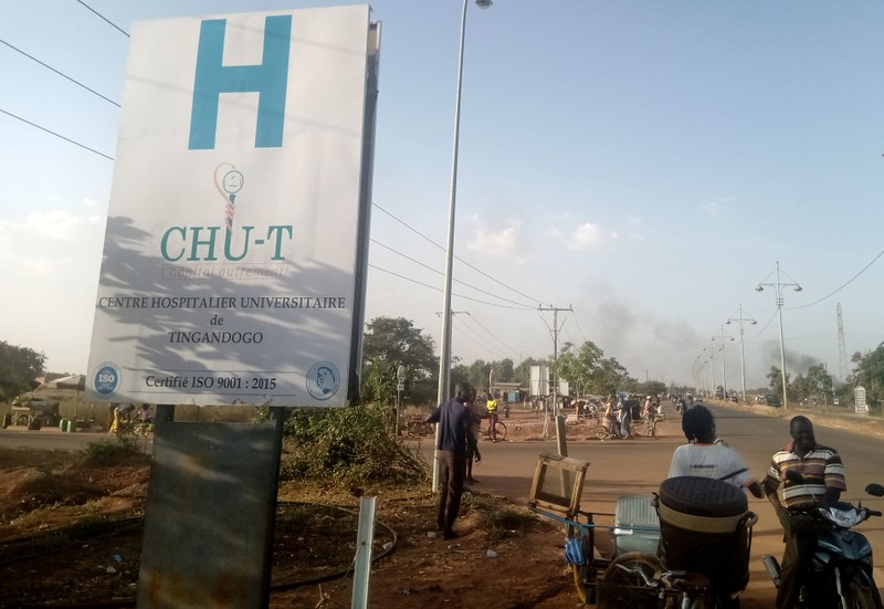 People are seen near a hospital in Ouagadougou, where some of the wounded were taken for treatment after an ambush on workers near a Canadian-owned mine