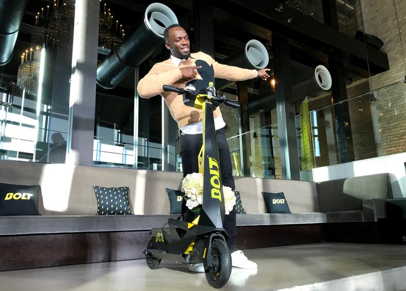 Olympic gold medallist Usain Bolt poses for a photograph as he shows off an electric scooter at a launch event in Tokyo