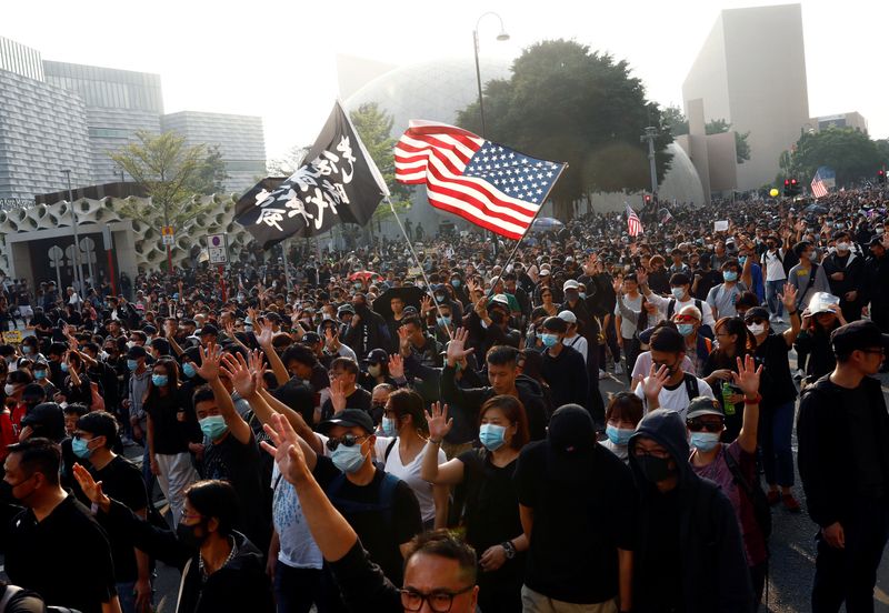 Anti-government protesters raise their hands as they attend the