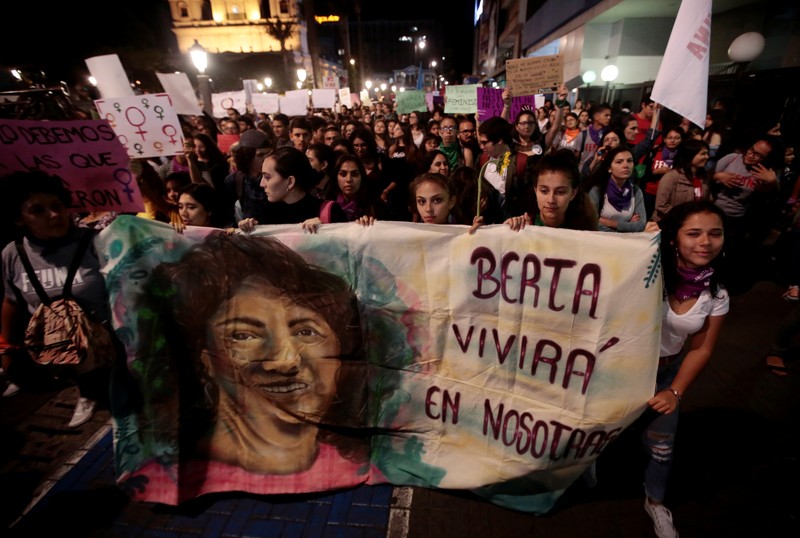 Women display a banner at a march during International Women's Day in San Jose