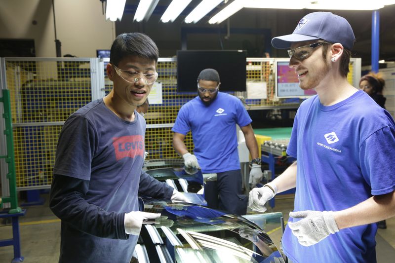 Wong He (left) working with Kenny Taylor (center) and Jarred Gibson (right) in the furnace tempering area of the Fuyao factory in Dayton, Ohio from the film AMERICAN FACTORY
