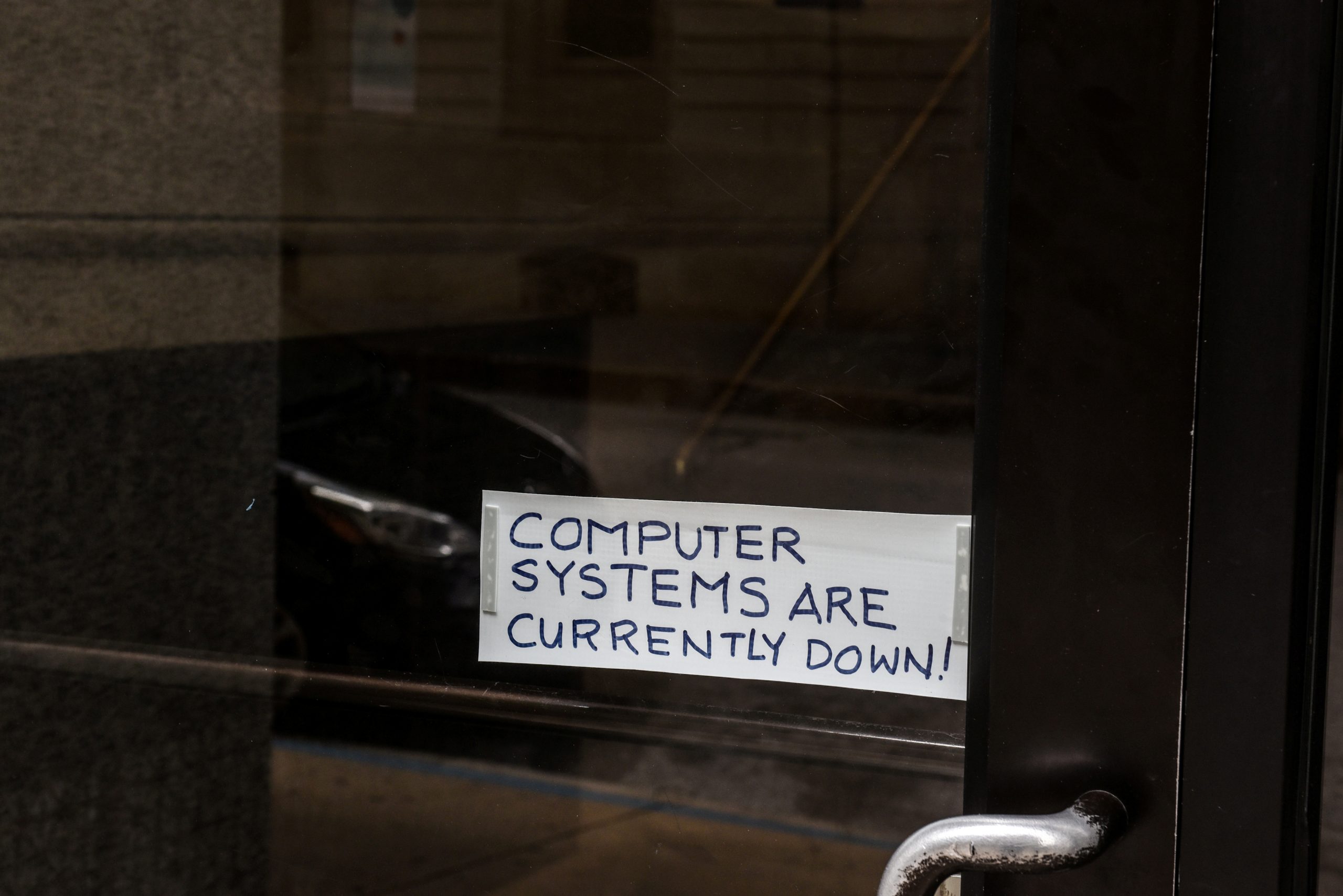 FILE PHOTO: A sign referring to the hacked computer system of Baltimore City is taped to a door near Baltimore City Hall in Baltimore, Maryland
