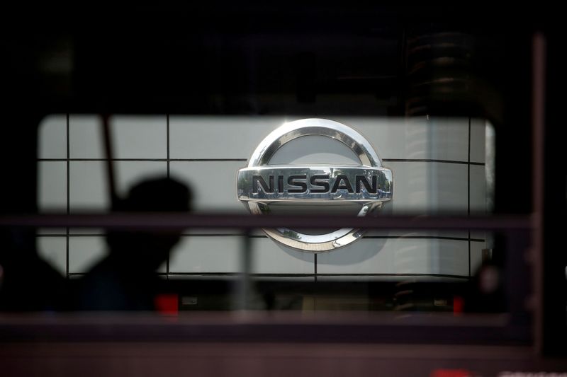 The logo of Nissan is seen through a window of a bus passing by its dealership in Seoul