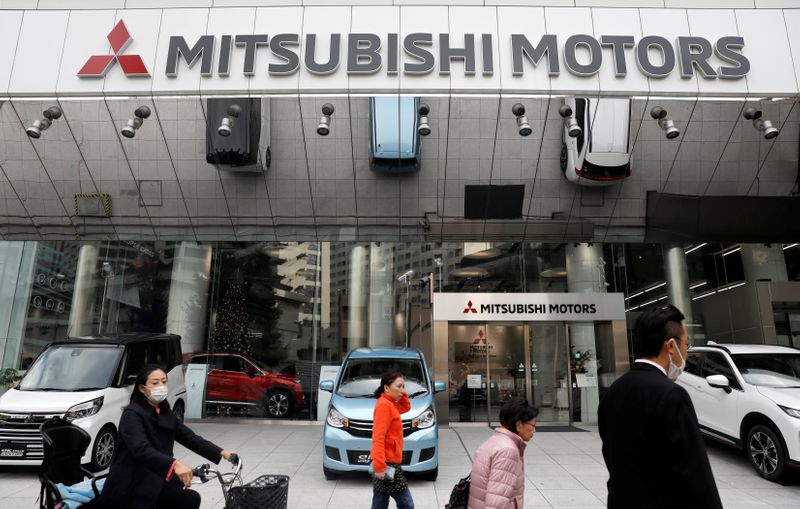 People walk in front of Mitsubishi Motors Corp's headquarters in Tokyo