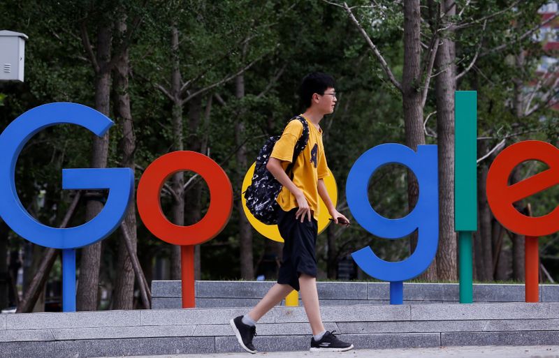 A man walks past the brand logo of Alphabet Inc's Google outside its office in Beijing