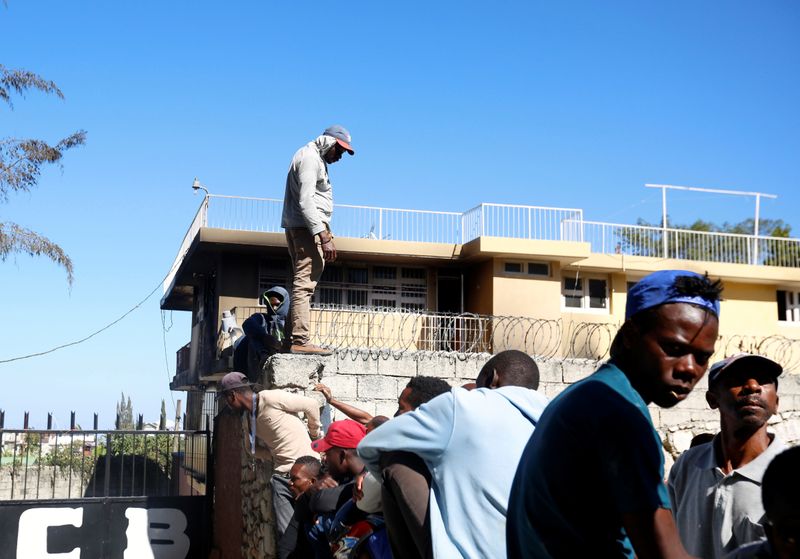 People gather outside an orphanage after part of it was destroyed in a fire, in Port-au-Prince