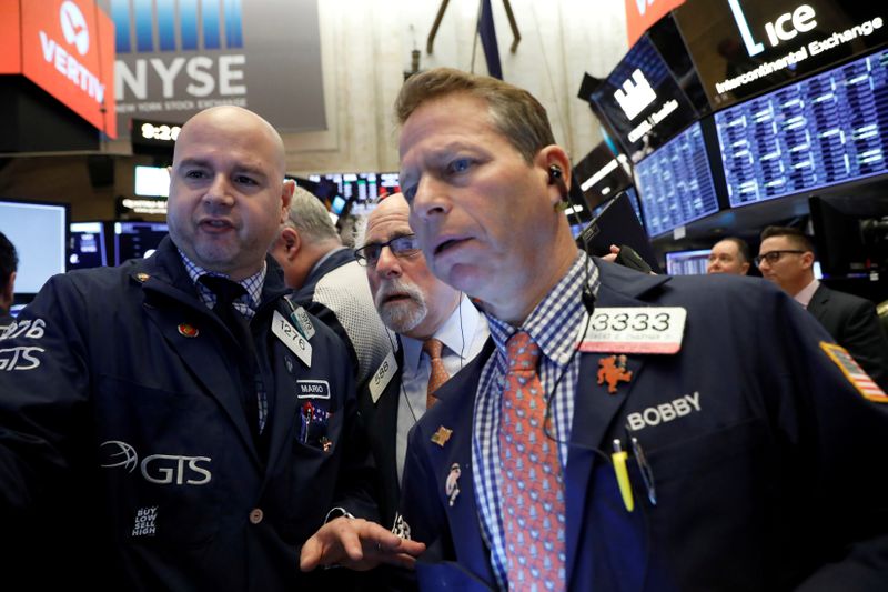 FILE PHOTO: Traders work on the floor at the NYSE in New York