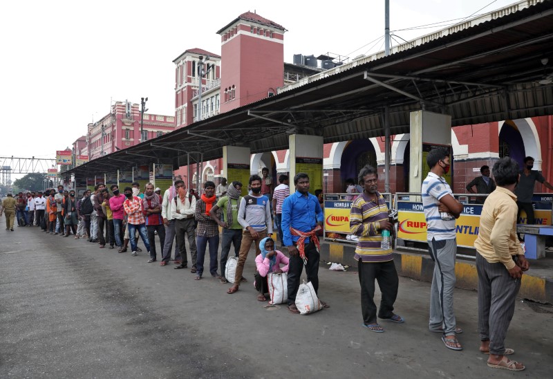 Migrant workers wait in a queue to receive free food outside Howrah railway station after India ordered a 21-day nationwide lockdown to limit the spreading of Coronavirus disease (COVID-19), in Kolkata