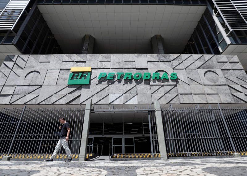 FILE PHOTO: A man walks in front of the headquarters of Petroleo Brasileiro S.A. (Petrobas) in Rio de Janeiro