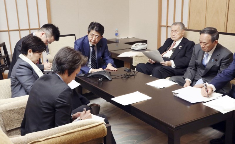 FILE PHOTO: Japan's PM Abe attends a telephone conference with IOC President Bach in Tokyo