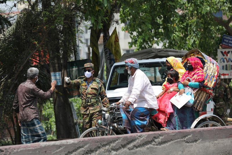 An army personnel stops people riding on a rickshaw at a check post during government imposed countrywide shutdown amid concerns over the coronavirus disease (COVID-19) outbreak in Narayanganj