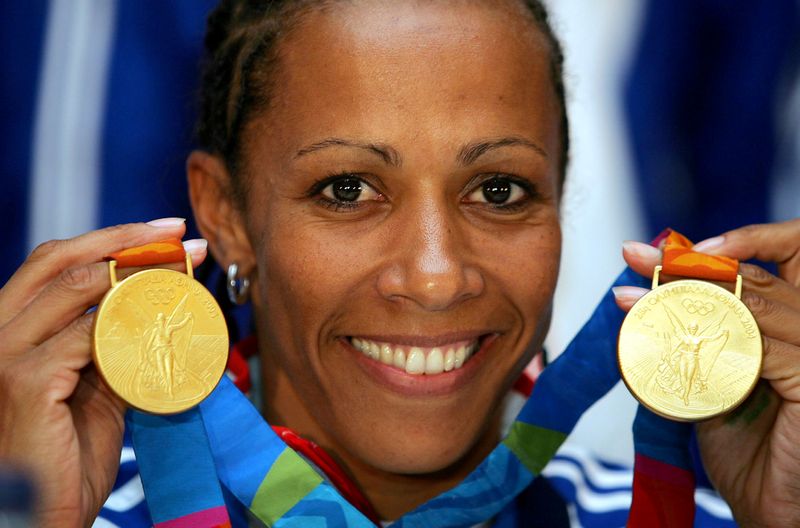 FILE PHOTO: Kelly Holmes, Olympic champion over 800m and 1500m, displays her two gold medals minutes after her a..
