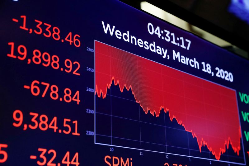 FILE PHOTO: A screen displays trading information over the floor of the New York Stock Exchange (NYSE) in New York
