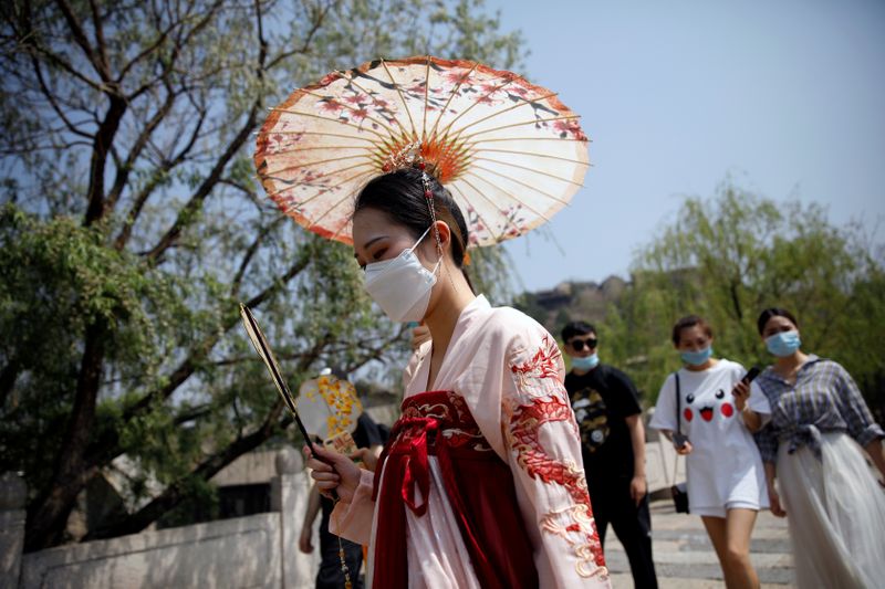 A woman wearing face mask and traditional Chinese clothing visits Gubei Water Town on the first day of the five-day Labour Day holiday, following the coronavirus disease (COVID-19) outbreak, on the outskirts of Beijing