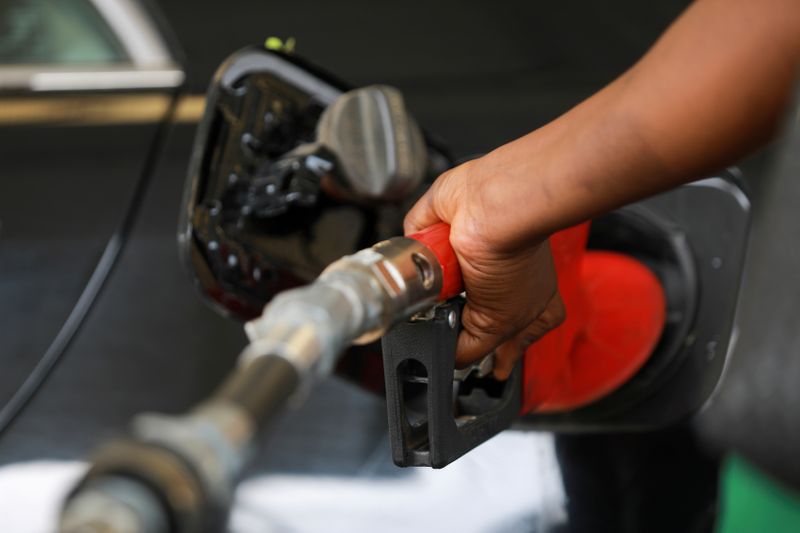 FILE PHOTO: A gas station attendant pumps fuel into a customer's car at the NNPC Mega petrol station in Abuja