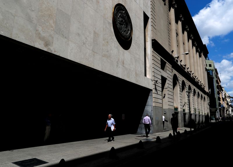 Pedestrians walk past the facade of the Buenos Aires Stock Exchange, in Buenos Aires
