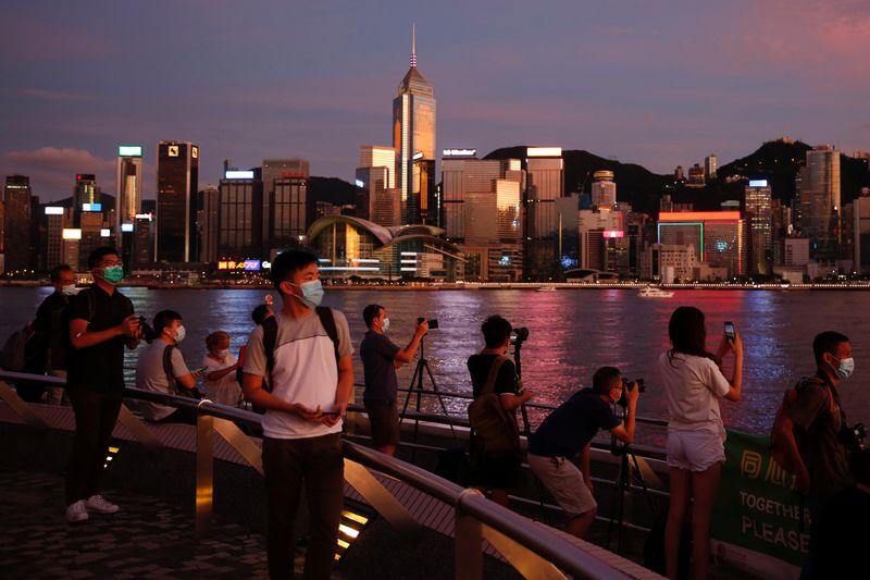 People enjoy the sunset view with a skyline of buildings during a meeting on national security legislation, in Hong Kong