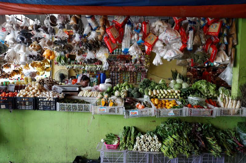 A woman waits for customers inside a food market in Paranaque, Metro Manila