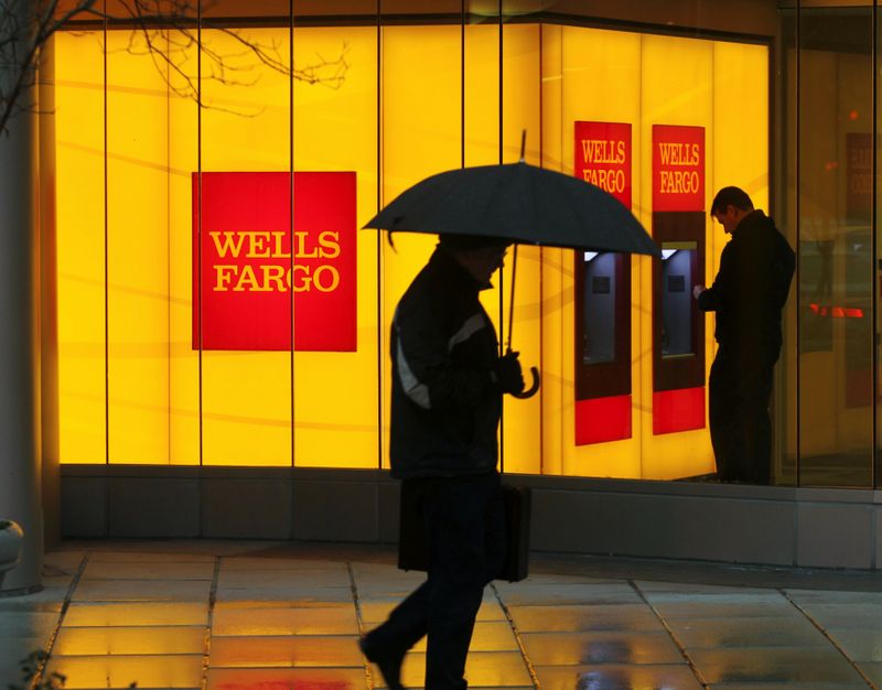 FILE PHOTO: FILE PHOTO: A man walks past a Wells Fargo Bank branch on a rainy morning in Washington