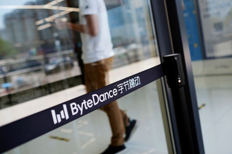 FILE PHOTO: Man walks by a logo of Bytedance, which owns short video app TikTok, at its office in Beijing