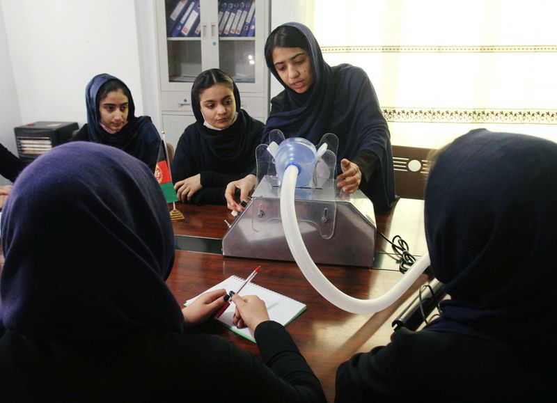 Members of an Afghan all-female robotics team work on an open-source and low-cost ventilator in Herat