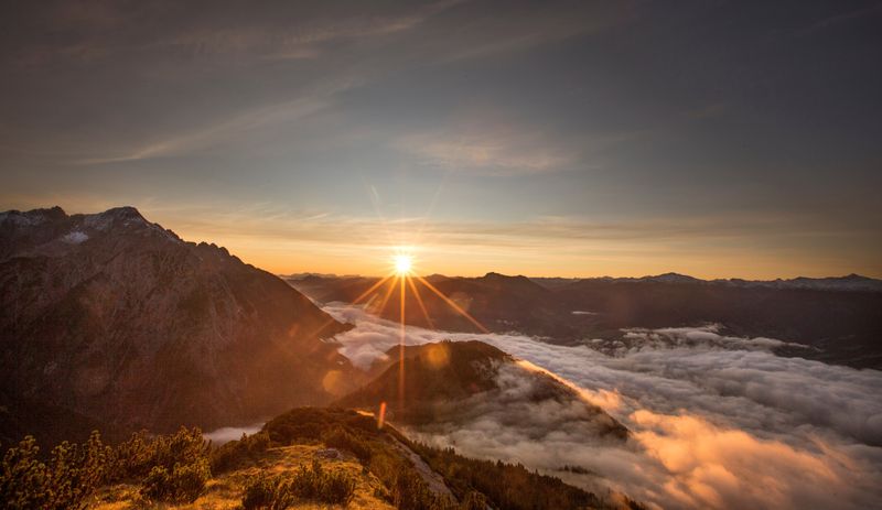 FILE PHOTO: The sun rises over mountain summits in the Austrian village of Absam