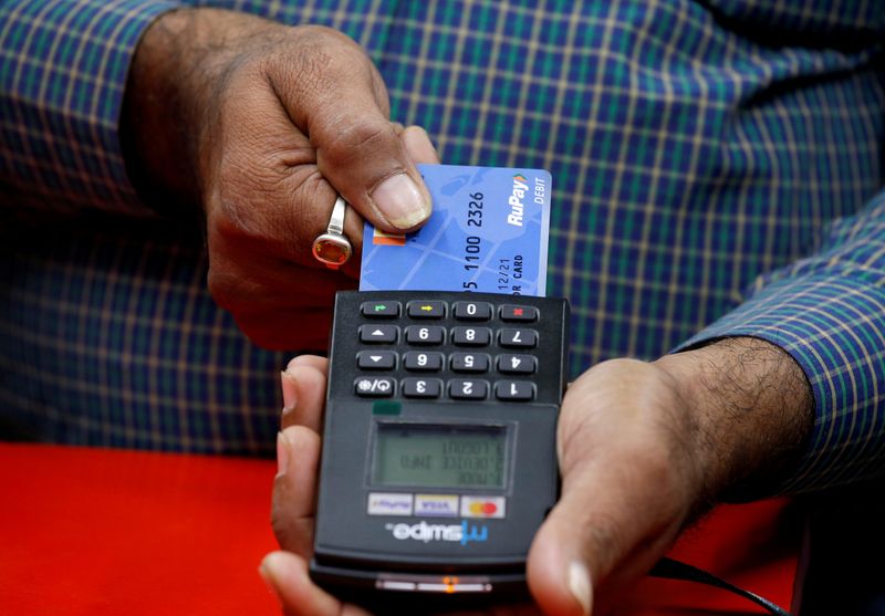 FILE PHOTO: A shopkeeper swipes a customer's debit card with the logo of RuPay at an electronics goods store in Kolkata