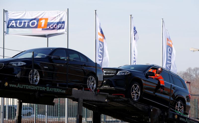 A worker loads a second hand car on a car transporter truck at the Auto1.com company grounds in Zoerbig