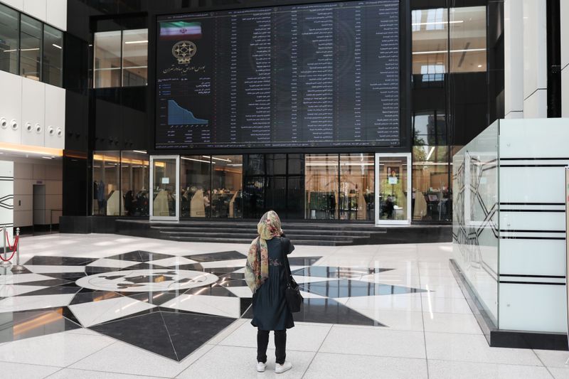 A woman looks at electronic board showing stock prices, following the outbreak of the coronavirus disease (COVID-19), at Tehran Stock Exchange in Tehran