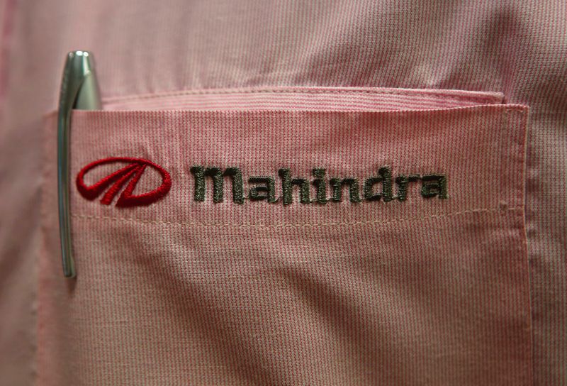 The logo of Mahindra & Mahindra Ltd is pictured on the pocket of a salesman's shirt as he poses inside the company's showroom in Mumbai