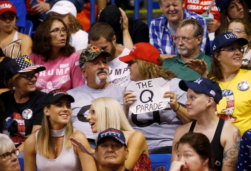 FILE PHOTO: A supporter holds a QAnon sign as U.S. President Donald Trump addresses a campaign rally at Mohegan Sun Arena in Wilkes-Barre, Pennsylvania