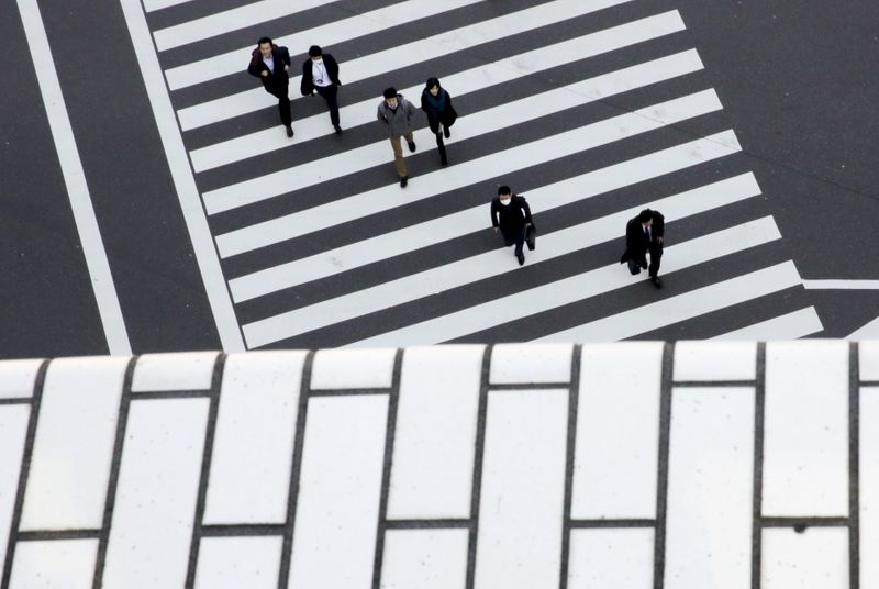 FILE PHOTO: People cross a street in a business district in Tokyo