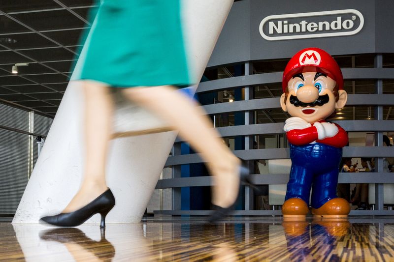 FILE PHOTO: Woman walks past figure of
