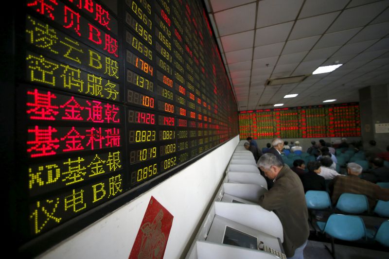 Investors look at computer screens showing stock information at a brokerage house in Shanghai