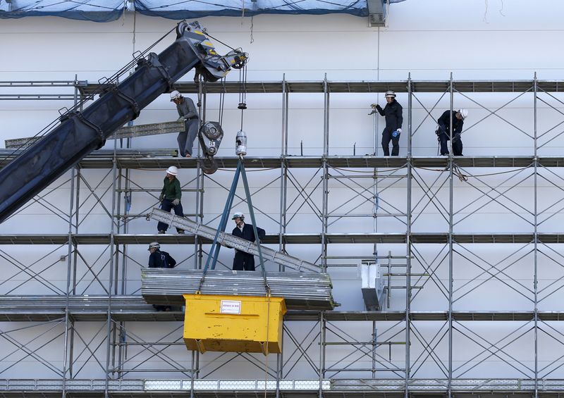 FILE PHOTO: Men work near a crane at a construction site in Tokyo