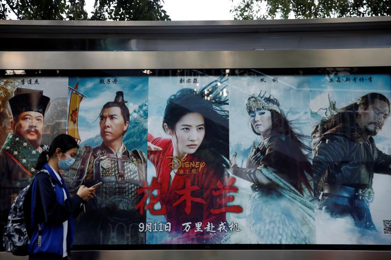 Woman walks past an advertisement promoting Disney's movie