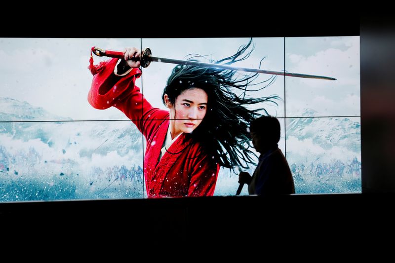 Cleaner walks past screens promoting Disney's movie