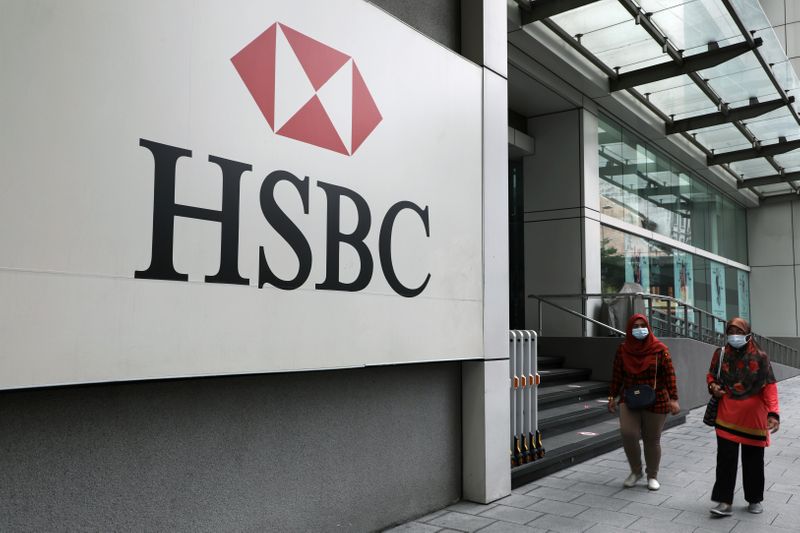 Women wearing protective masks walk past HSBC headquarters, amid the coronavirus disease (COVID-19) outbreak in Kuala Lumpur