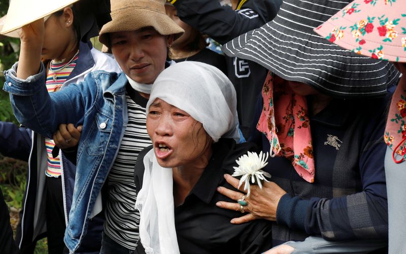 FILE PHOTO: Tran Thi Hien cries while following an ambulance carrying her daughter's coffin during the funeral ceremony at her village in Nghe An province