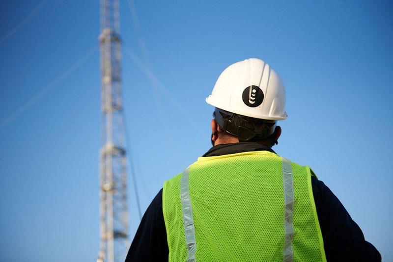 A worker stands in front of a mobile tower in Denver