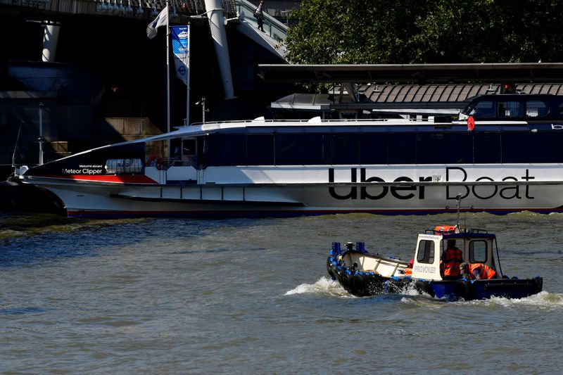 Uber signage is seen on the side of a river taxi on the river Thames, in London