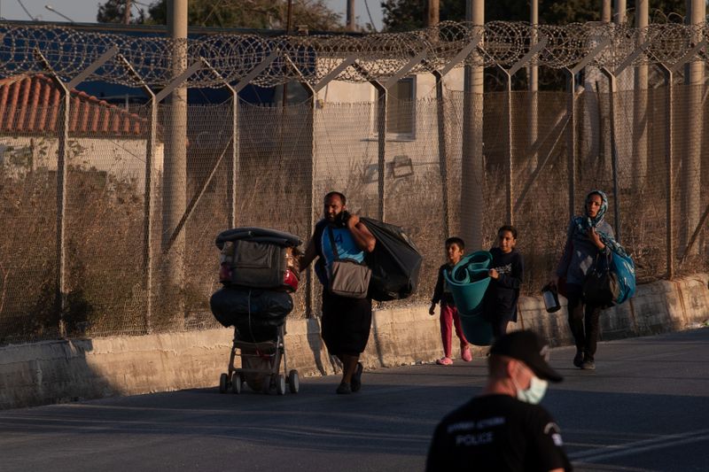 A family from the destroyed Moria camp for refugees and migrants arrives at a new temporary camp, on the island of Lesbos
