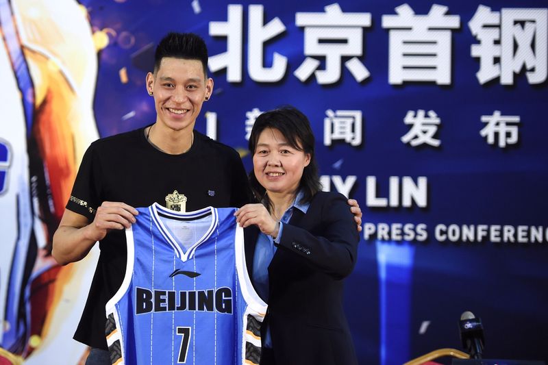 FILE PHOTO: Former NBA star Jeremy Lin poses with his Beijing Ducks jersey at a news conference in Beijing