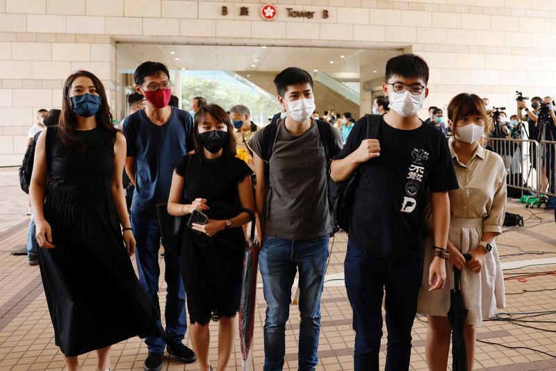 Pro-democracy activists, including Joshua Wong, Eddie Chu and Lester Shum arrive at the West Kowloon Courts before entering a courtroom to face charges related to illegal assembly during Tiananmen vigil, in Hong Kong