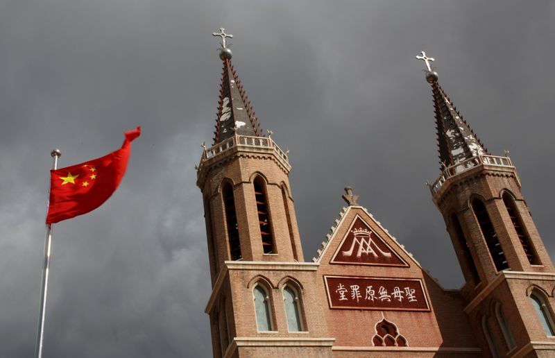 FILE PHOTO: The Chinese national flag flies in front of a Catholic church in the village of Huangtugang