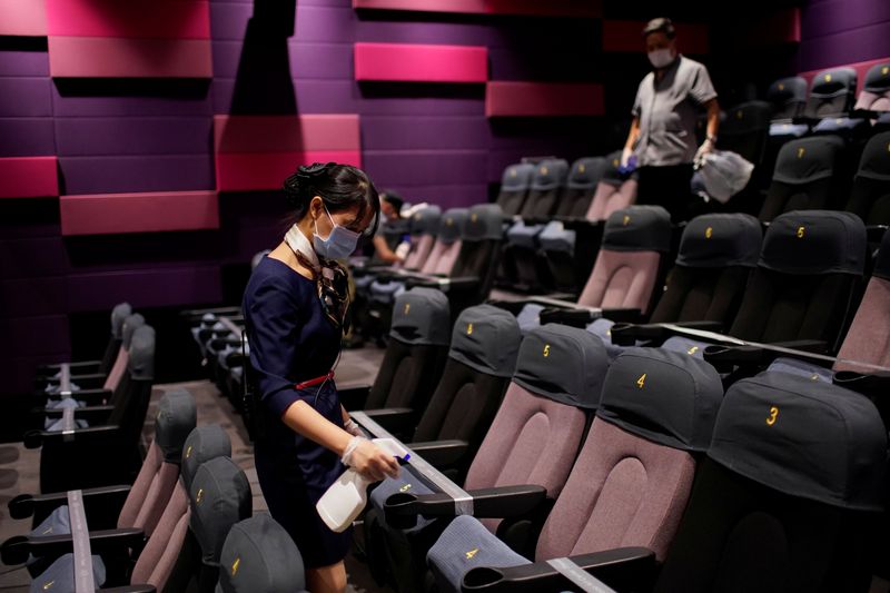 A staff member wearing a face mask disinfects seats in a cinema as it reopens following the coronavirus disease (COVID-19) outbreak, in Shanghai